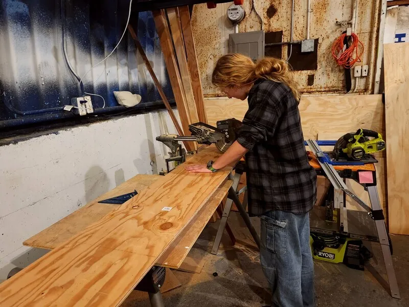 Using the saw in the van hangar.